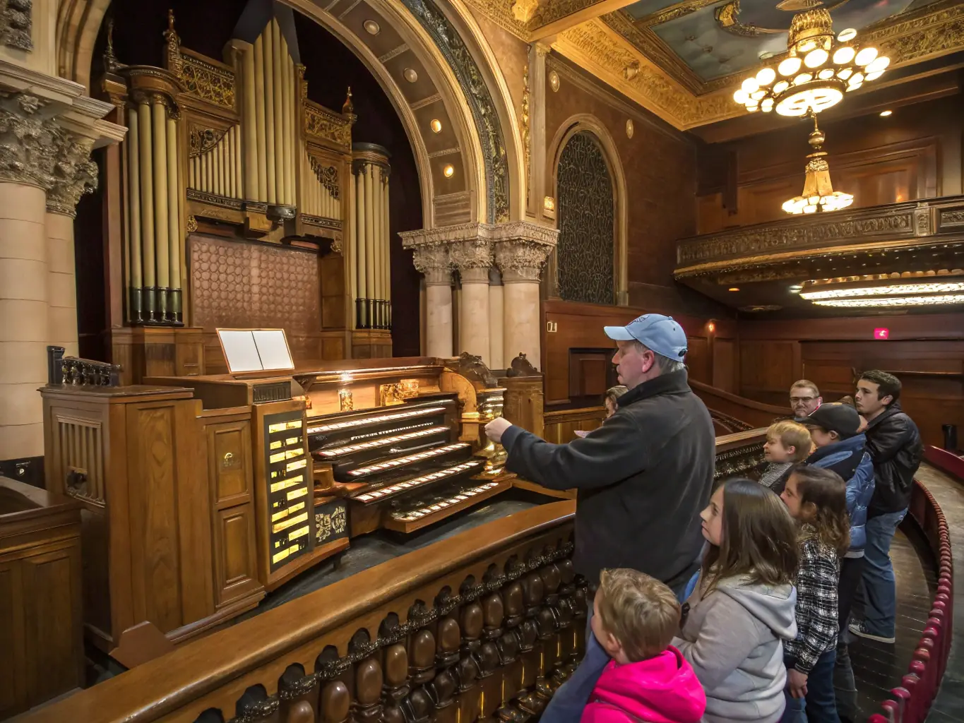 A photograph depicting a masterclass session with a renowned organist, guiding students through advanced techniques on the grand organ of Saint Jean, showcasing the educational aspect of the association's programs.