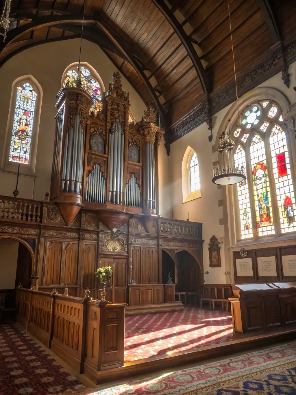 A wide shot of a concert featuring the grand organ of Saint Jean de Caen, with the organist visible and the audience captivated by the performance. The church is beautifully illuminated.