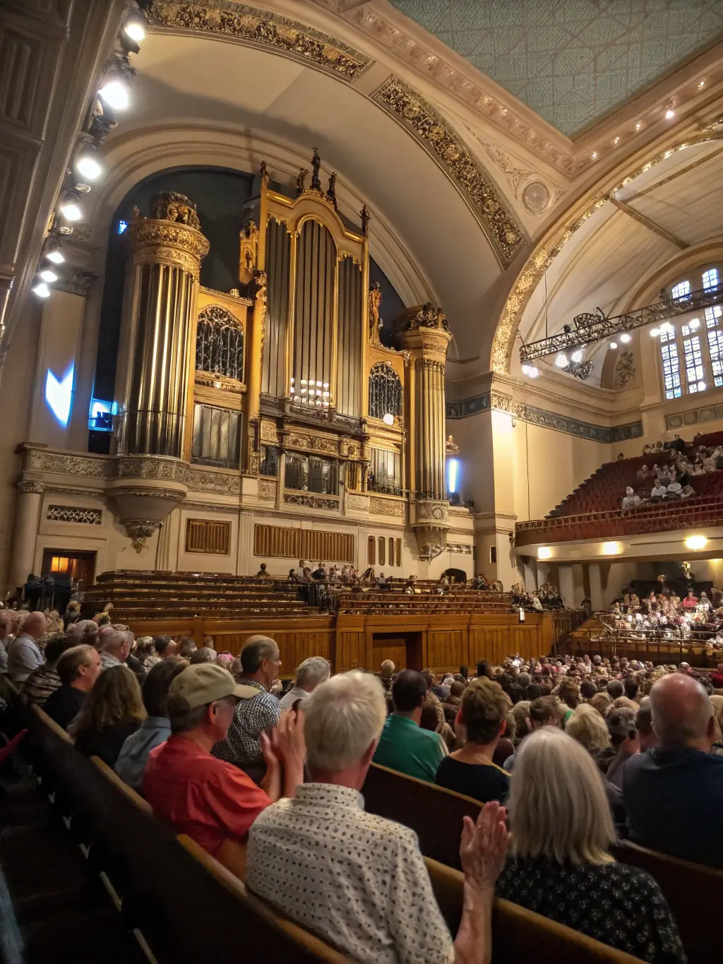 A photograph of a public concert featuring the Saint Jean organ, with the church filled with an audience enjoying the performance.